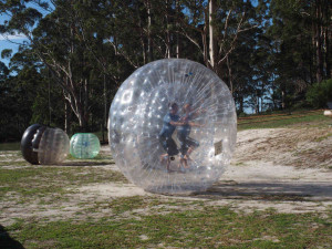 Two people running in a Zorb ball